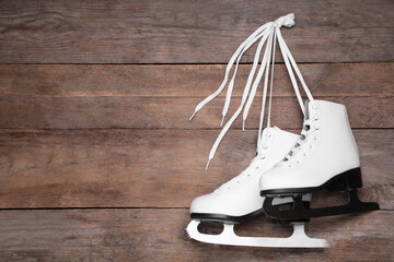 Sticker - Pair of skates hanging wooden background. Space for text