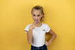 Young beautiful child girl standing over isolated yellow background disgusted with her hand inside her mouth