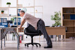 © Elnur - Old male employee doing physical exercises at workplace