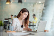 © amnaj - Pretty and charming asian businesswoman sitting happily smiling with laptop computer in the office.