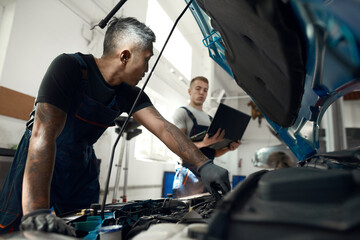 Wall Mural - Mechanics doing computer diagnostic of car engine