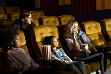 Do not use a mobile phone in the cinema. Group of diversity people watching movie in cinema theater with popcorn and drinks.