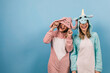 Gorgeous girl in unicorn pajama laughing to camera. Fascinating female models in kigurumi expressing happiness.