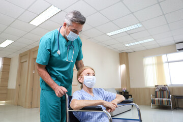 Wall Mural - Doctor or assistance staff help or assist a elder patient woman while sitting on wheelchair in the hospital, eldercare concept