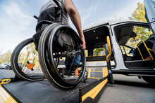 A Man In A Wheelchair Moves To The Lift Of A Specialized Vehicle 