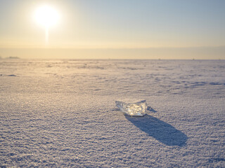 Wall Mural - an ice floe lies on the surface of a frozen lake on a sunny day