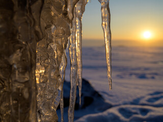 Wall Mural - icicles on the shore of a frozen lake at sunset. timelapse