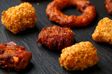 Wall Mural - Fried Buffalo onion rings, tater tots and sweetcorn fritters with ketchup on rustic stone board. Party take away food