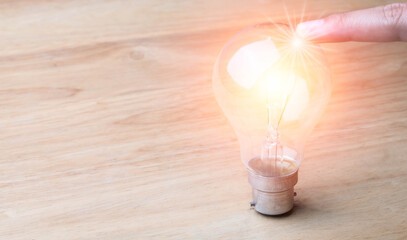 Close up human Finger Touch  light bulbs or lamp thinking ideas of  with innovative technology and creativity. concept