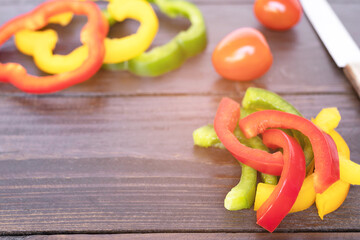 Sticker - Slices of bell pepper on rustic wooden table background with copy space. 