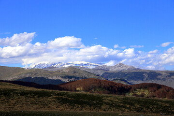 View on series of Apennine mountains with snow and vegetation of different colors, Abruzzo, Italy