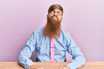 Sticker - Young irish redhead man wearing business shirt and tie sitting on the table looking at the camera blowing a kiss on air being lovely and sexy. love expression.