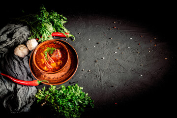 Poster - Tomato soup with meat and vegetables, pepper chili, smoked paprika, decorated with green in a dark brawn bowl on dark background