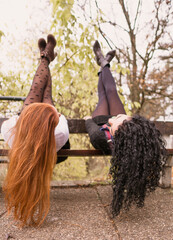 Wall Mural - two girls with long hair having fun in the park, autumn outfit.Two pretty stylish women have fun 