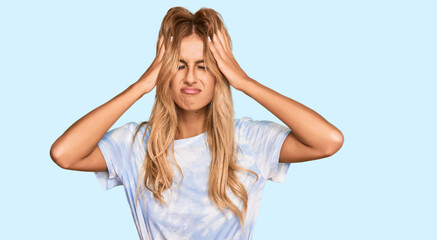 Canvas Print - Beautiful blonde young woman wearing casual tie dye shirt suffering from headache desperate and stressed because pain and migraine. hands on head.