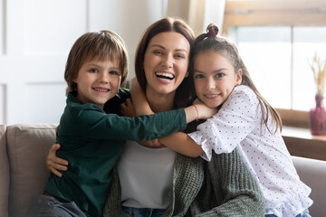 portrait of two cute little children hug cuddle young mom feel grateful and thankful. happy small ki