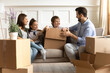© fizkes - Overjoyed young Caucasian family with little kids have fun unpack unbox relocating to new home together. Happy parents buyers renters with children celebrate relocation to own house. Rental concept.