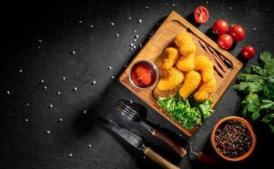 Wall Mural - Breaded chicken nuggets with tomato sauce on dark background. Fast food, food at home