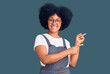 © Krakenimages.com - Young african american girl wearing casual clothes smiling and looking at the camera pointing with two hands and fingers to the side.