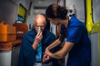 © Anna Kosolapova - A female paramedic checking her patient's pulse, the patient is having an oxygen mask on.