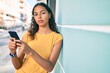 © Krakenimages.com - Young african american girl with unhappy expression using smartphone at city.