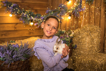 Wall Mural - Pretty girl holding a rabbit in her arms