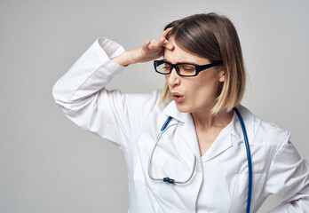 Wall Mural - doctor in a medical gown with a stethoscope around his neck puzzled look gray background