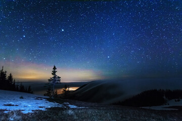 Wall Mural - Space starry nights with a bright Milky Way on the backdrop of tourists with tents.