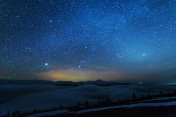 Wall Mural - space starry nights with a bright milky way on the backdrop of tourists with tents.