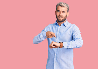 Poster - Young handsome blond man wearing elegant shirt in hurry pointing to watch time, impatience, upset and angry for deadline delay