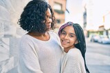 Fototapeta Miasto - Beautiful african american mother and daughter smiling happy and hugging. Standing with smile on face standing at the city.