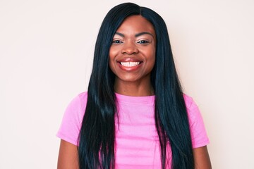 Wall Mural - Young african american woman wearing casual clothes looking positive and happy standing and smiling with a confident smile showing teeth