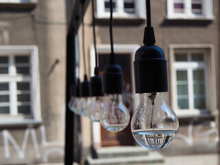 Hanging light bulbs on the background of the old building.