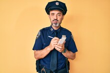 Middle Age Hispanic Man Wearing Police Uniform Writing Traffic Fine Puffing Cheeks With Funny Face. Mouth Inflated With Air, Catching Air.