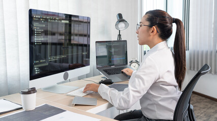 Young Asian woman Programmer Typing code working with computer at table, coding cyberspace and Web Development Concept