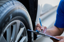 A Car Maintenance Worker Is Checking The Quality Of The Tires That Are Worn Out, Should They Be Replaced Or Not He Takes Care Of The Car For The Customer.