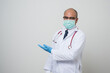 © Chanakon - Asian bald Doctor in white coat, stethoscope, blue glove wearing face mask.pointing left hand to beside camera isolated on white background.