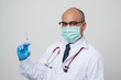 © Chanakon - Asian bald Doctor in white coat, stethoscope, blue glove holding a syringe.and look into camera isolated on white background.