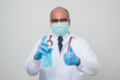 © Chanakon - Asian bald Doctor in white coat, stethoscope, blue glove showing alcohol.hand gel and get thumb up isolated on white background.