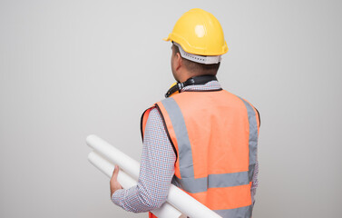 Rear view asian civil engineer holding paperwork blueprint roll standing in studio. Worker wearing hard hat on isolated white background.