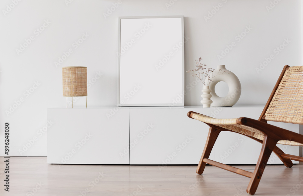 Blank picture frame mockup on white wall. White living room design. View of modern scandinavian style interior with chair. Home staging and minimalism concept - obrazy, fototapety, plakaty 