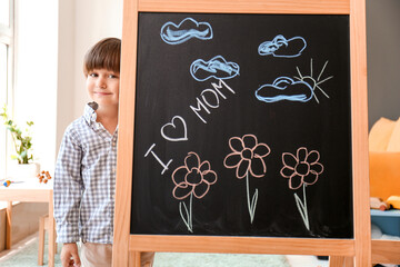 Poster - Cute little boy with drawn flowers for mother on blackboard in kindergarten