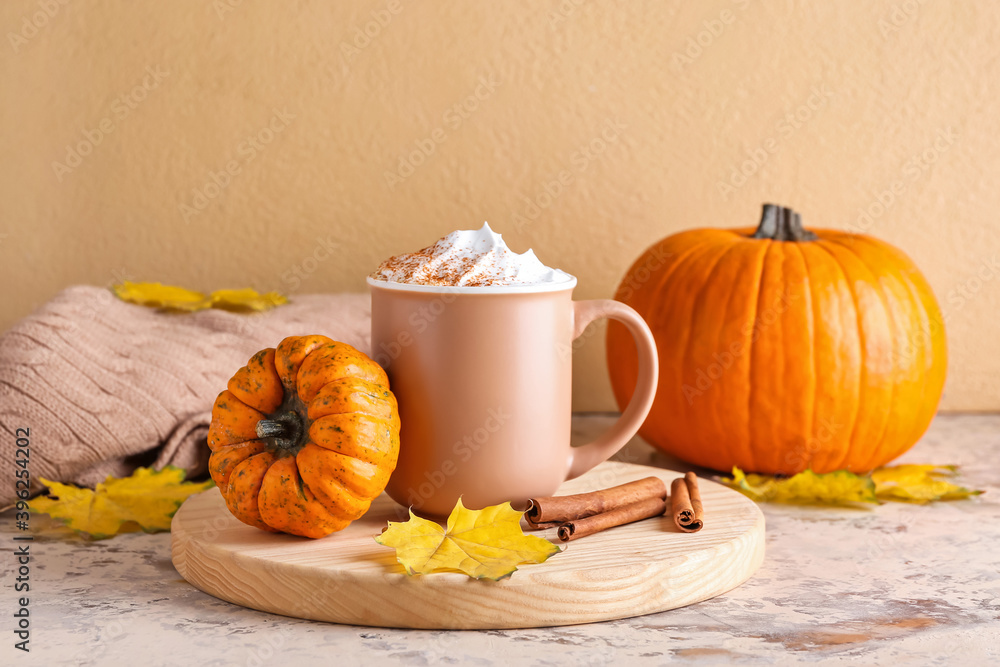 Cup of pumpkin cappuccino on table
