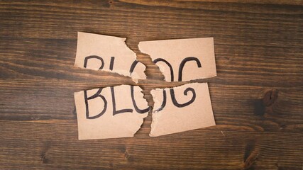 Wall Mural - BLOG. Torn cardboard with an inscription on a wooden background