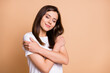 © deagreez - Photo portrait of dreamy girl hugging herself smiling isolated pastel beige color background