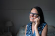 © Kevin - Middle-aged woman talking on her cell phone from her room