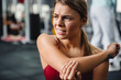 Unhappy athletic sportswoman with elbow pain working out in gym