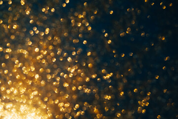 Wall Mural - Gold glitter on dark blue bokeh abstract light defocused background.