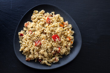 Wall Mural - fresh vegetable salad with couscous on black plate