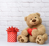 Fototapeta Pokój dzieciecy - big teddy bear and cardboard box with red bow